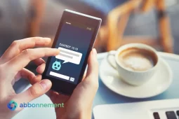 Persona che usa uno smartphone con un chatbot bancari mentre beve un caffè.