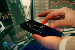 Mano che utilizza un app per investimento sullo smartphone con grafici finanziari sullo schermo.