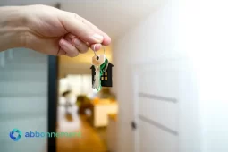 Mano che tiene un mazzo di chiavi di casa con portachiavi a forma di abitazione, simbolo di Crowdfunding Immobiliare.