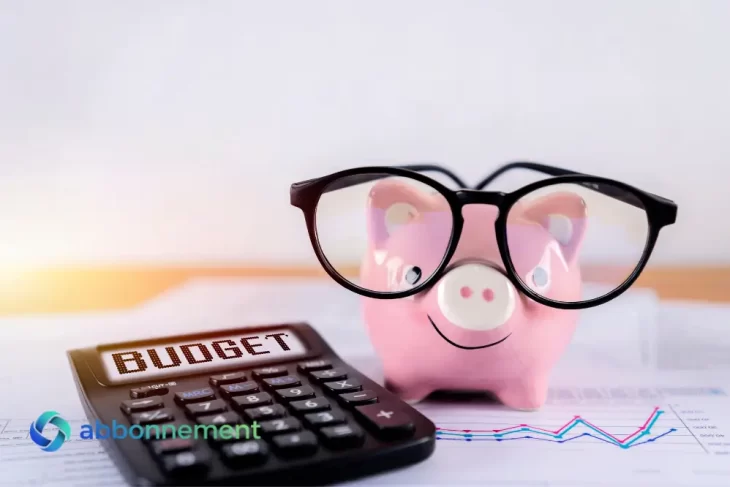 Salvadanaio con occhiali, calcolatrice e grafici, simbolo di educazione finanziaria e gestione del budget.