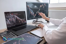 Trader che analizza grafici su più schermi mentre applica strategie di social trading.