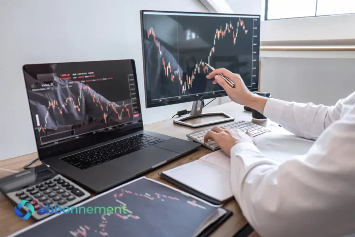 Trader che analizza grafici su più schermi mentre applica strategie di social trading.