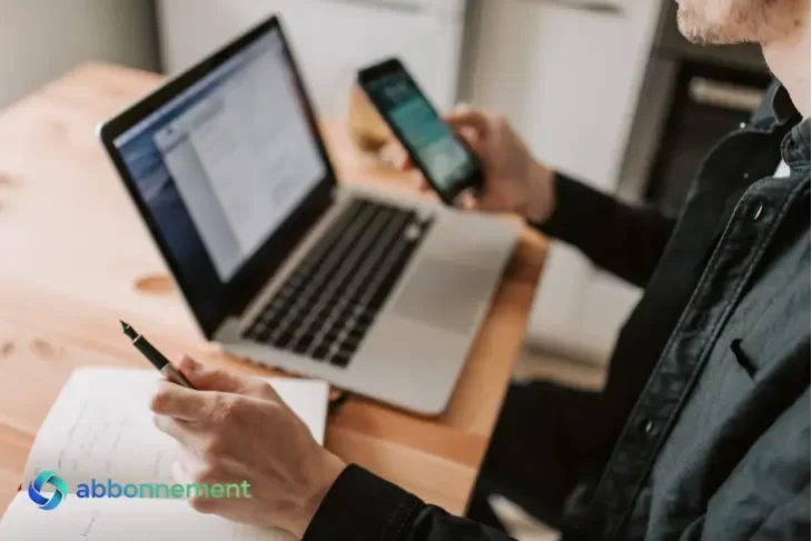 Persona usando laptop y celular para gestionar operaciones financieras relacionadas con el dólar digital.
