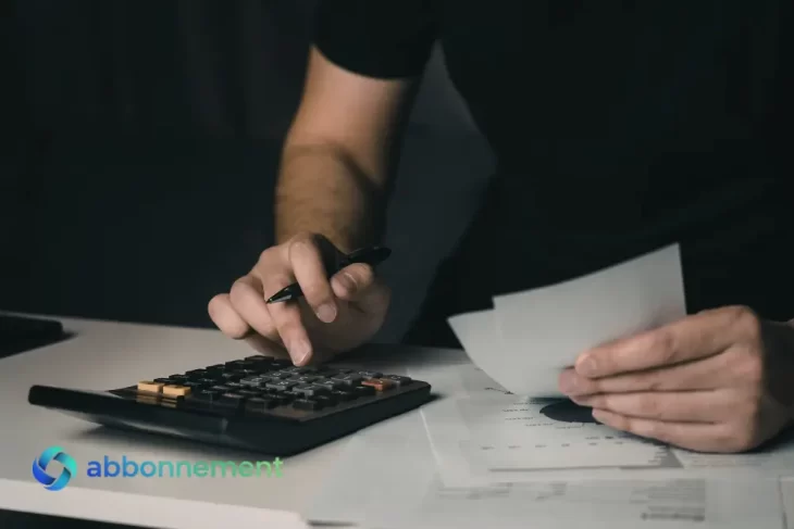 Persona usando calculadora y revisando papeles, imagen para explicar un presupuesto personal y controlar gastos.