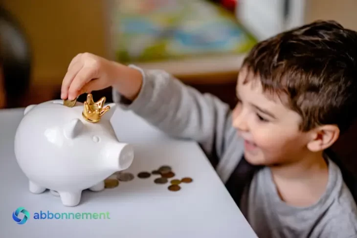 Niño poniendo una moneda en una alcancía blanca, con monedas sobre la mesa, simbolizando el Ahorro Informal.