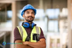 Lavoratore con casco e gilet riflettente che osserva in avanti, simbolo della preparazione della Dichiarazione ISEE.