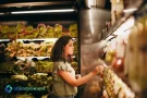 Mujer eligiendo alimentos en un supermercado, simbolizando la Compra en Mayoristas.