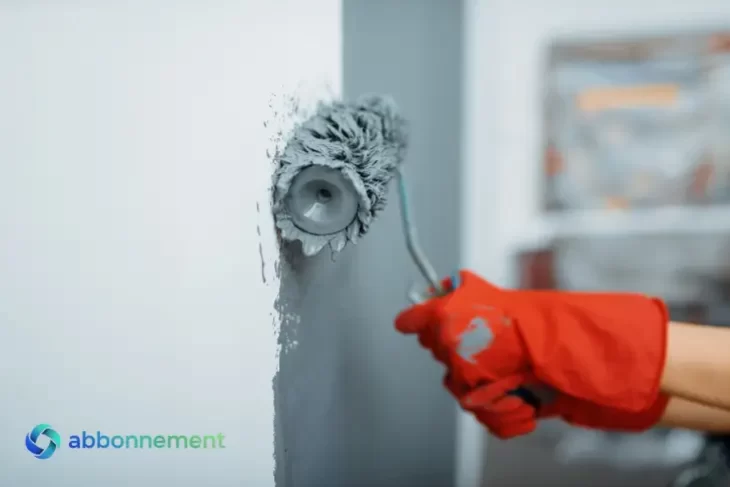 Mano pintando una pared con un rodillo, simbolizando Reparaciones Caseras.