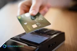 Pagamento contactless rischi, una mano avvicina una carta al lettore POS per un pagamento contactless.