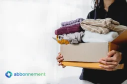 Persona con scatolone di vestiti per il decluttering di primavera.