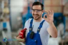Lavoratore sorridente celebra il Primo Maggio con gesto positivo