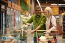 Coppia al supermercato confronta prodotti per risparmiare sulla spesa settimanale