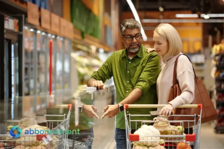 Coppia al supermercato confronta prodotti per risparmiare sulla spesa settimanale