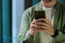 Uomo che usa uno smartphone per gestire i tuoi risparmi in modo sicuro.
