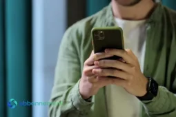 Uomo che usa uno smartphone per gestire i tuoi risparmi in modo sicuro.