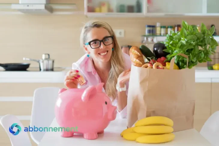 Donna in cucina con spesa e salvadanaio, simbolo di come risparmia sulla spesa alimentare grazie a una migliore pianificazione.