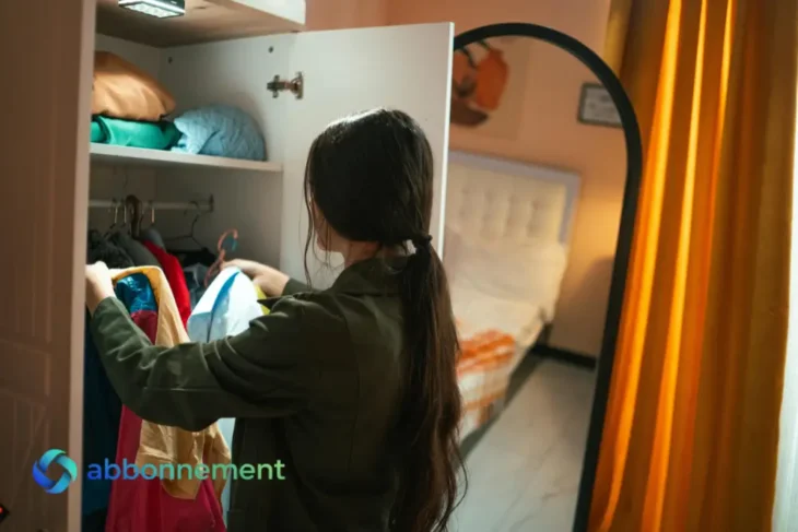 Mujer seleccionando ropa usada para generar ingresos extra en invierno.