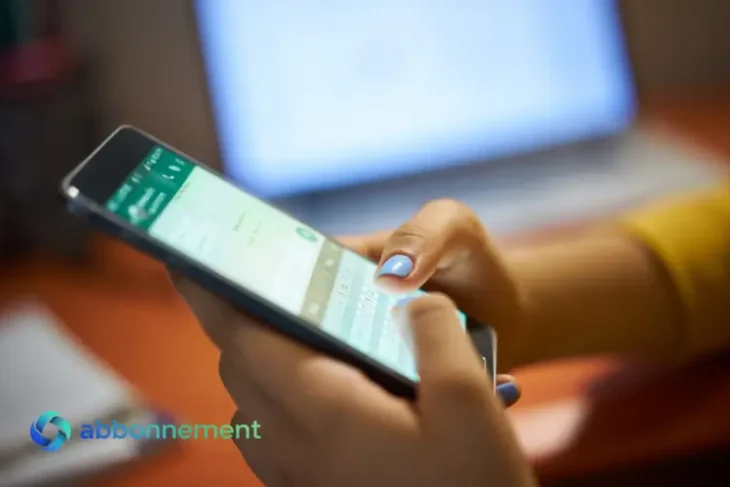 Persona al telefono, attenta alle truffe WhatsApp.